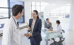 Doctor and businesswoman handshaking in meeting