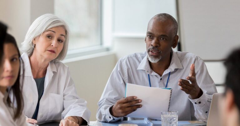 Senior businessman speaks seriously with medical staff